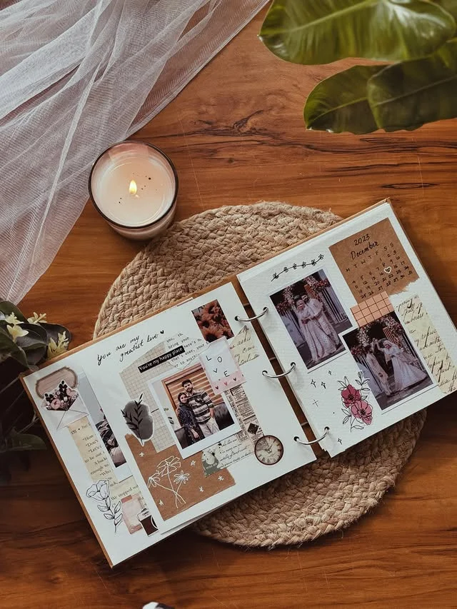 Open memory scrapbook with early photos and handwritten notes on a wooden table