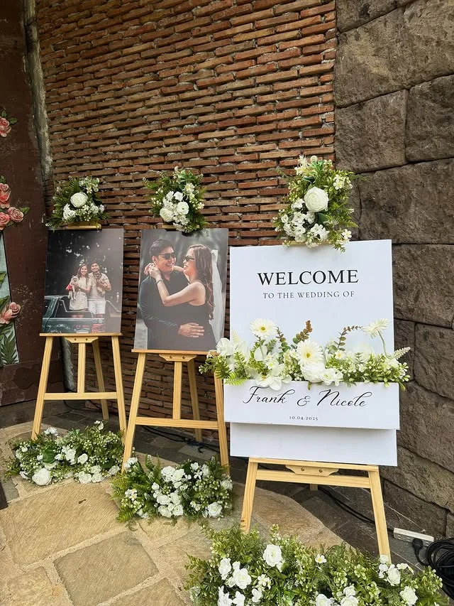 Photo easels at a party entrance displaying enlarged portraits of a couple