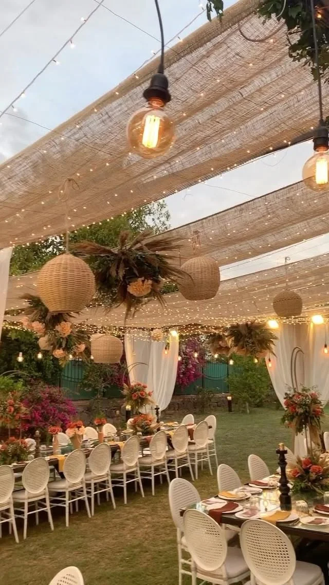 Canopy dinner with hanging lanterns, candles and soft gold decor for an evening celebration