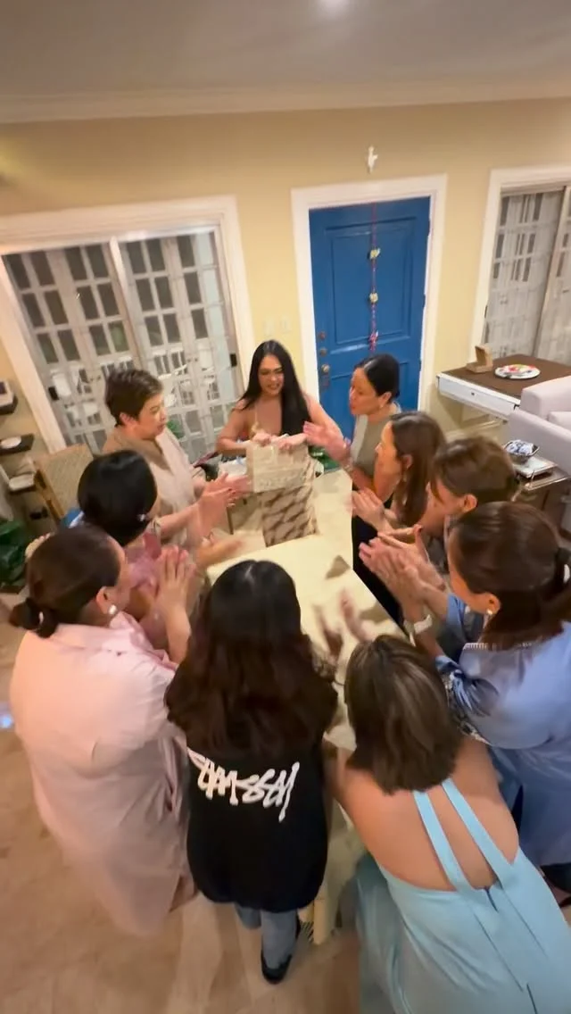 Group of women gathered in a circle playing a Christmas gift exchange game
