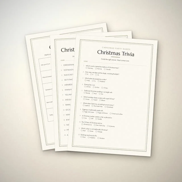 Printed Christmas trivia question sheets fanned out on a light table