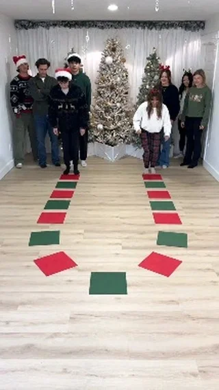 Group playing a red and green stepping path relay race game at Christmas