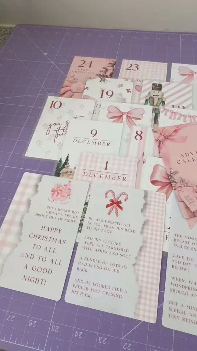 Pink and white printed advent calendar cards numbered 1 to 24 on a table
