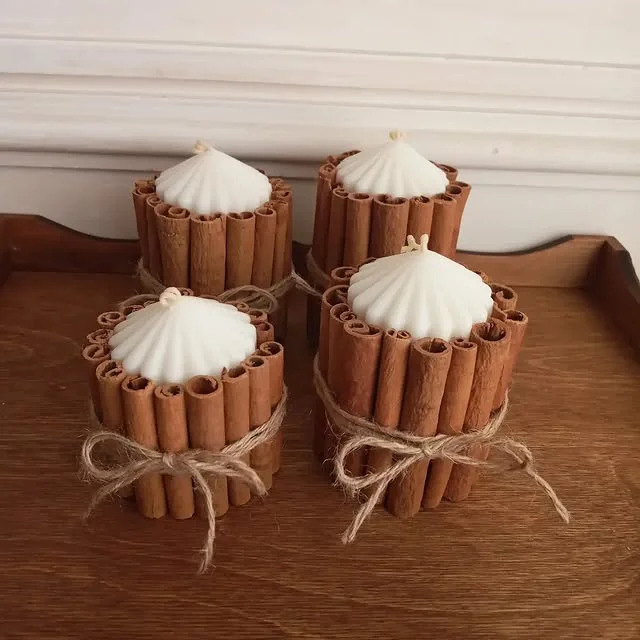 Candles wrapped in cinnamon sticks tied with twine bows