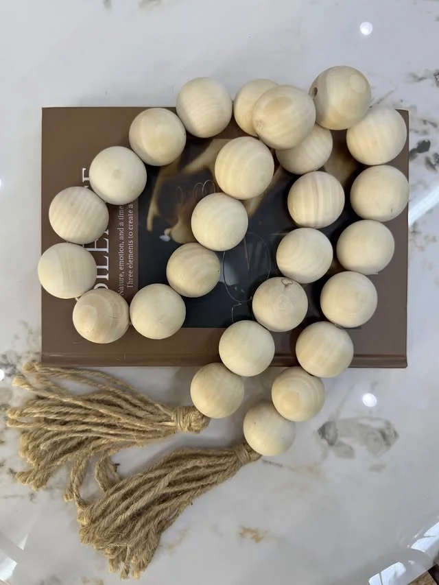 Wood bead garland with jute tassel styled on a book