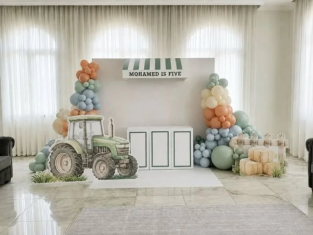 Tractor cutout with pastel balloon columns at a farm party