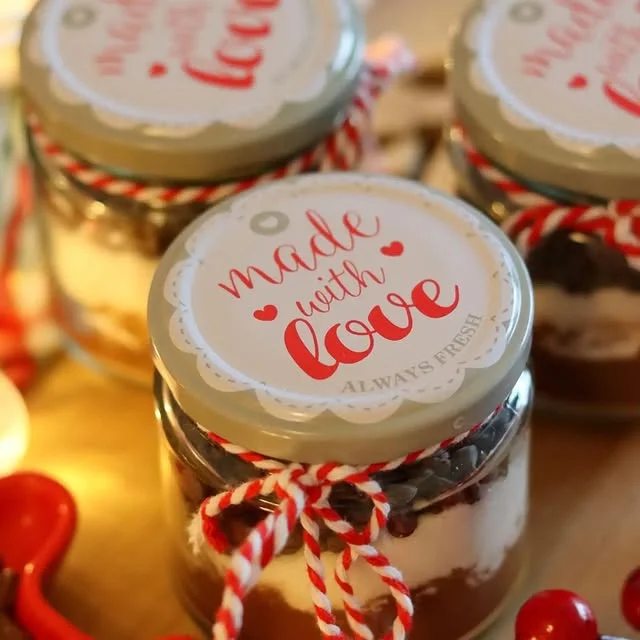 Small layered dessert jars with made with love lids tied with striped twine