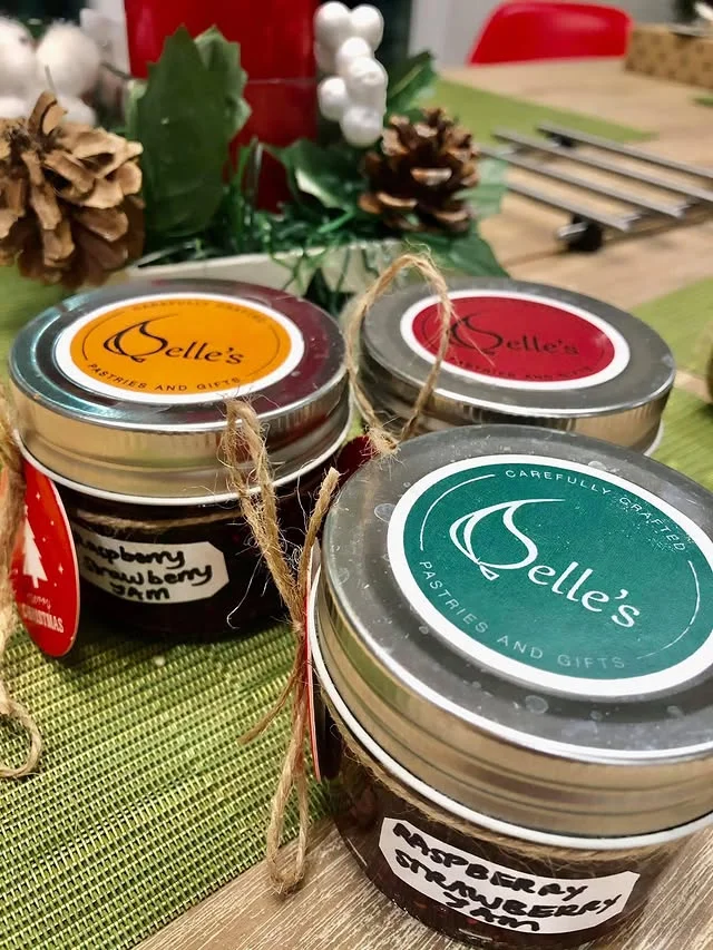 Three small jars of raspberry strawberry jam tied with twine
