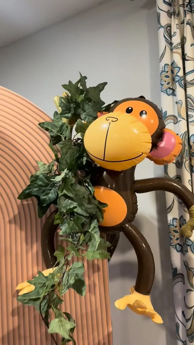 Plush monkey nestled in green foliage