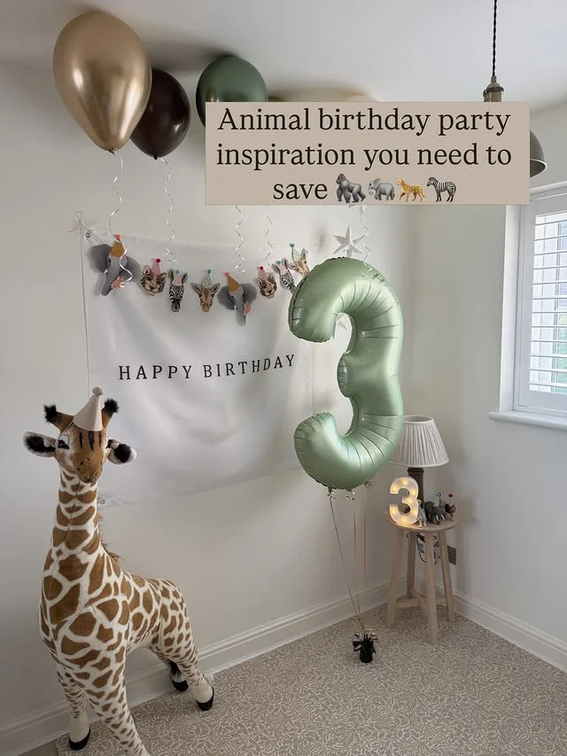 Birthday corner with a large giraffe figure, number balloon and animal head banner