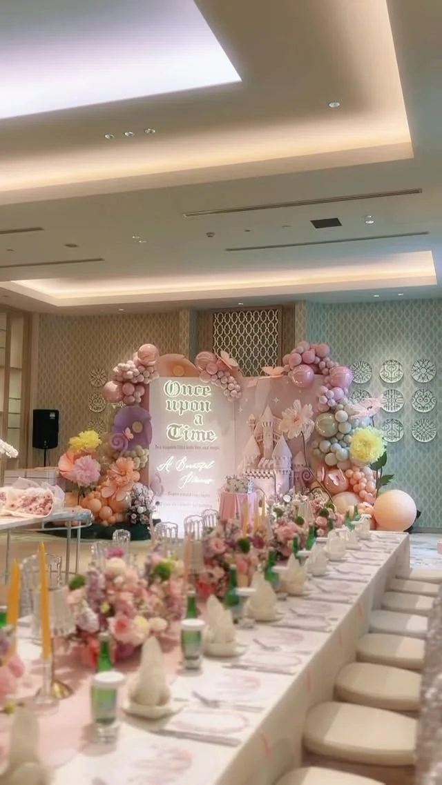 Long banquet table with white linens, pink runners and floral decor