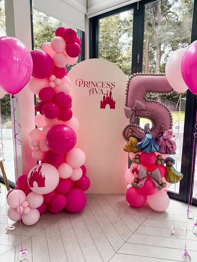 Soft pink arched backdrop with balloons for a princess fifth birthday
