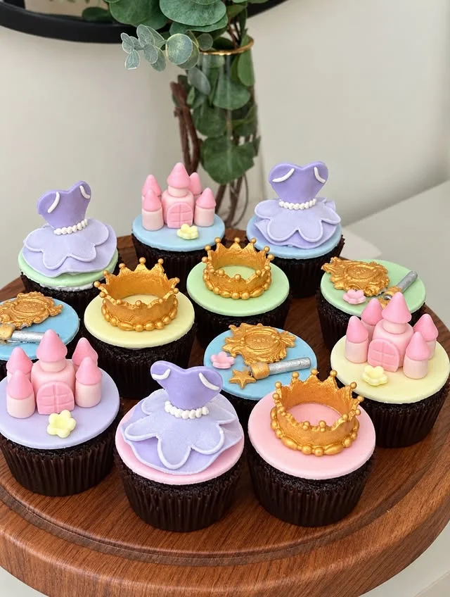 Princess themed cupcakes with fondant crowns, dresses and castle toppers