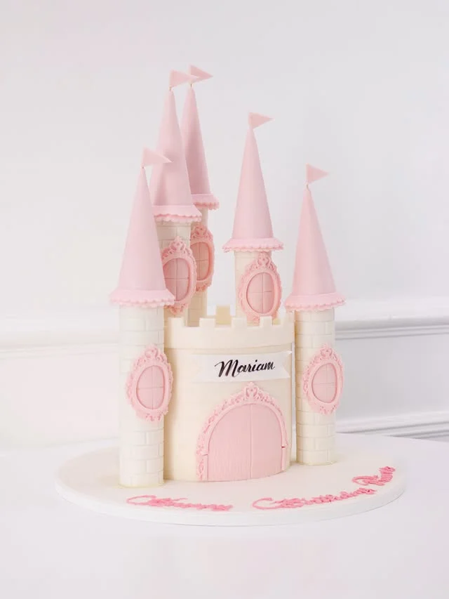 White castle cake with pink turrets, pink windows and a pink door