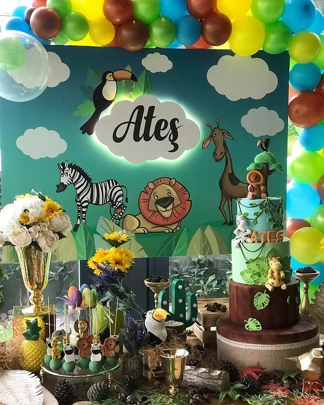 Personalized name sign above a tall tiered cake on a decorated cake table