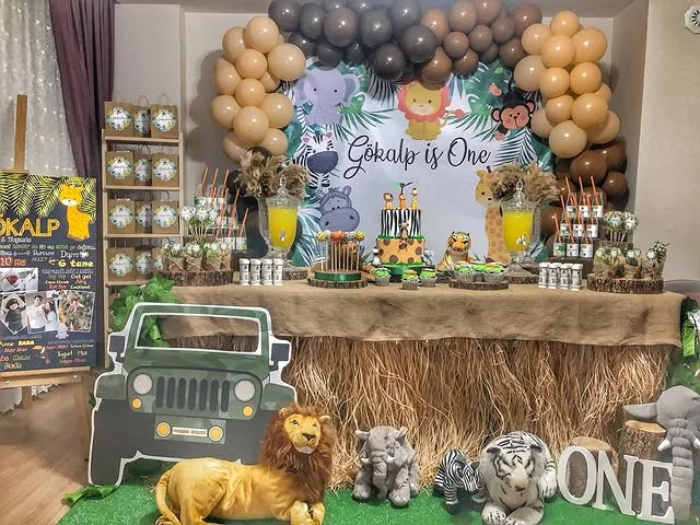 Rustic dessert table with a grass style cloth, toy jeep and lion figure