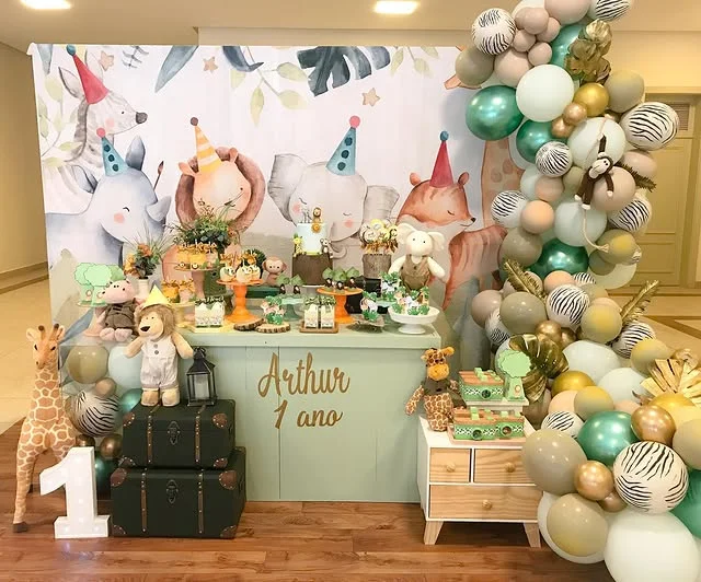 Dessert table with suitcases, treats and a painted animal backdrop