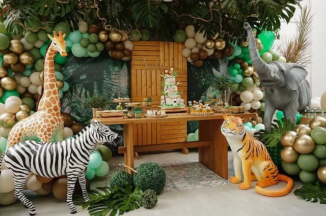 Life size zebra, giraffe, elephant and tiger figures around a dessert table
