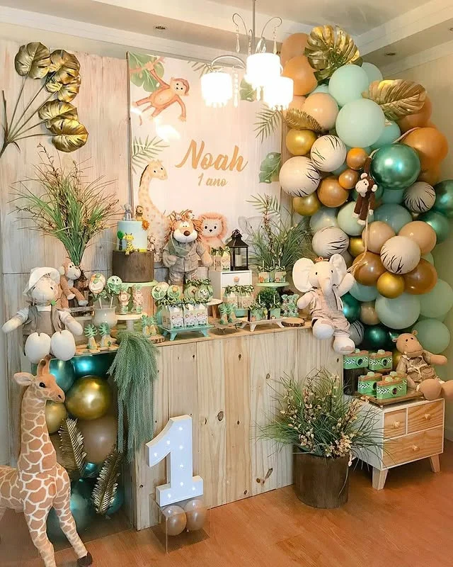 Wooden dessert table with plush animals, pastel balloons and a large number one