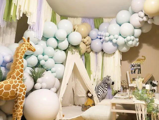 Pastel teepee corner with pale balloons, a giraffe figure and a low table