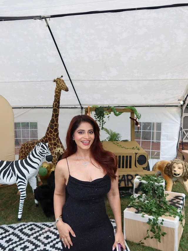 Safari tent party setup with giraffe and zebra cutouts and a toy jeep
