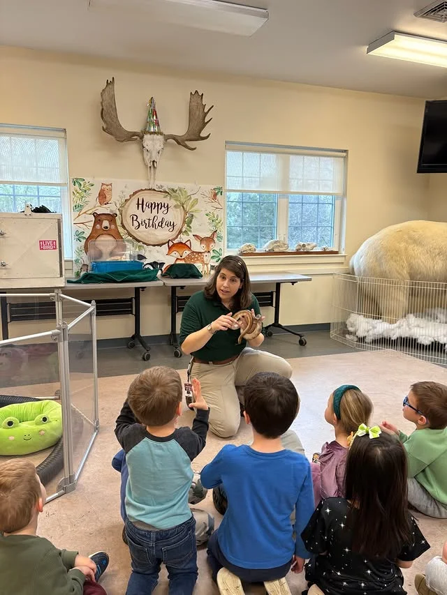 Zoo keeper talking to children at a birthday party room