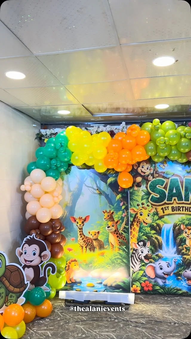 Safari themed stage backdrop with monkey cutout and colorful balloons