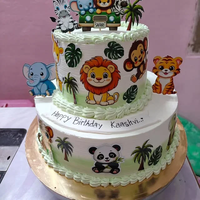 Two tier cake decorated with cartoon lion zebra panda and tiger animals
